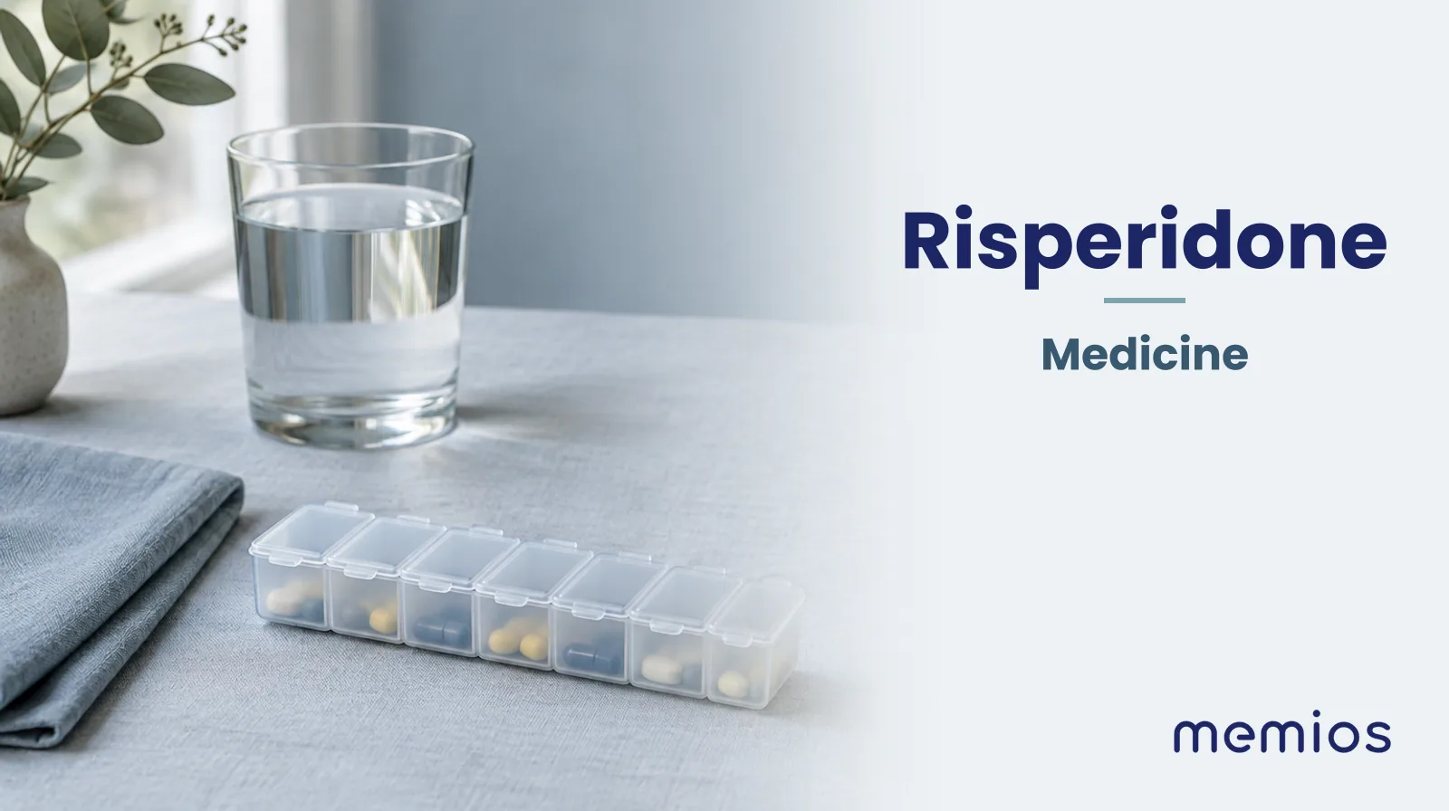 Photograph for Risperidone: plain unmarked tablets in a dish beside a glass of water on pale linen.
